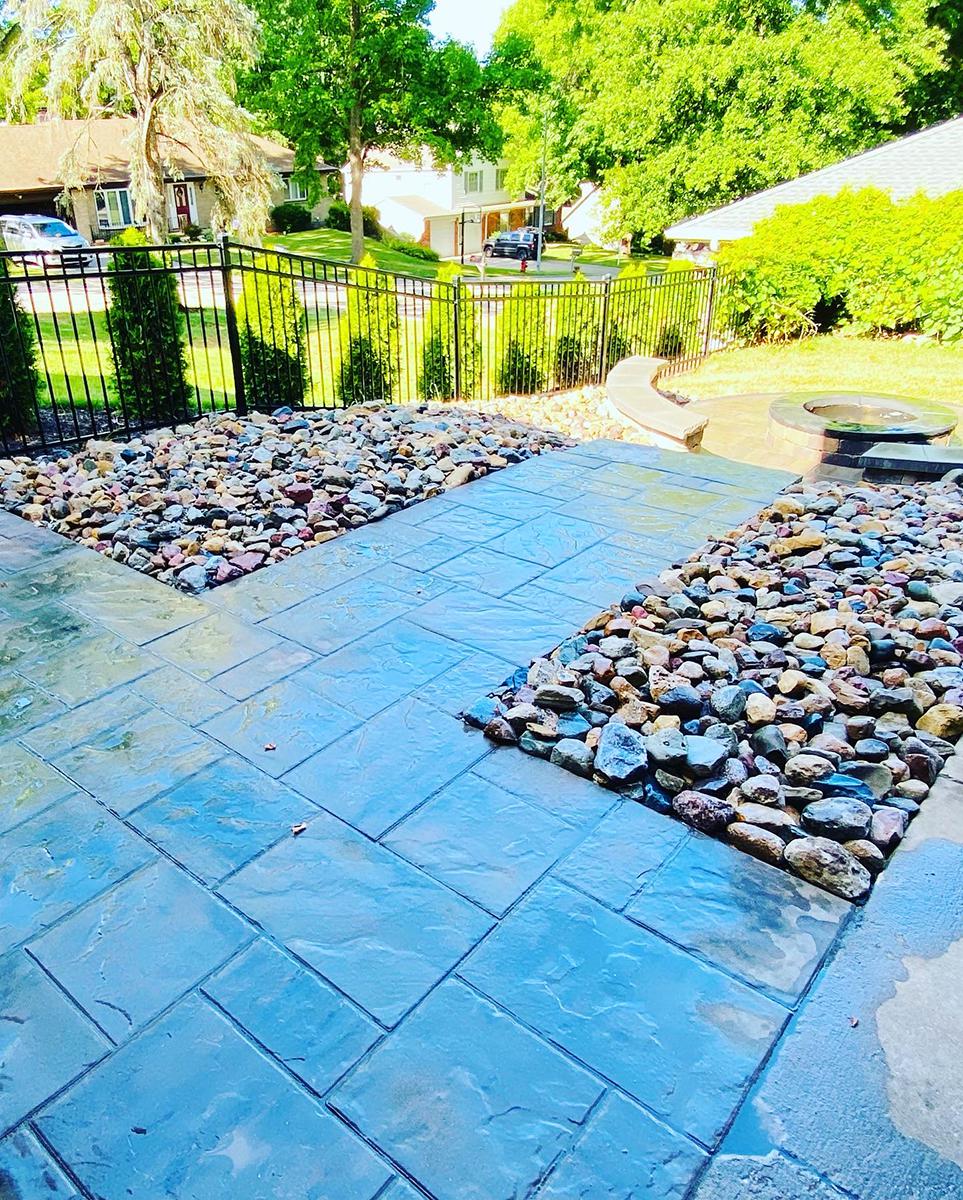 Custom multi-level paver patio with integrated fireplace and stone stairs by KC Outdoor Spaces
